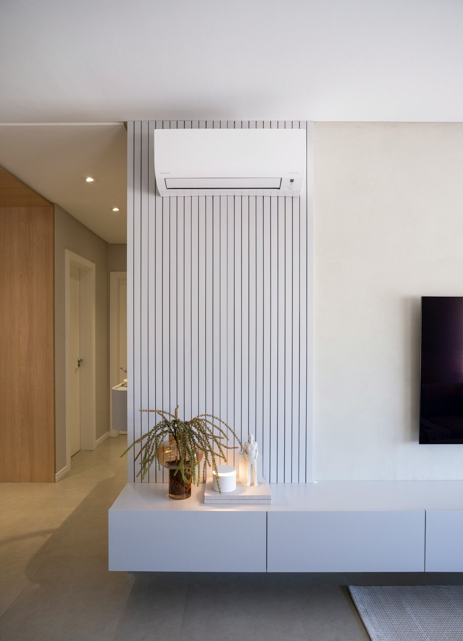Moderná split klimatizácia Daikin namontovaná na dizajnovej stene v svetlom minimalistickom interiéri